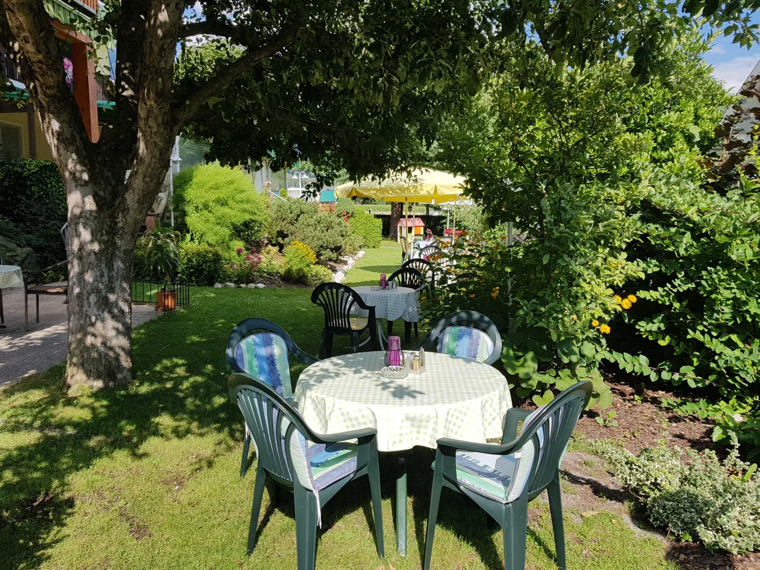 Die gemütliche Gartenterrasse mit an einem warmen Sommertag