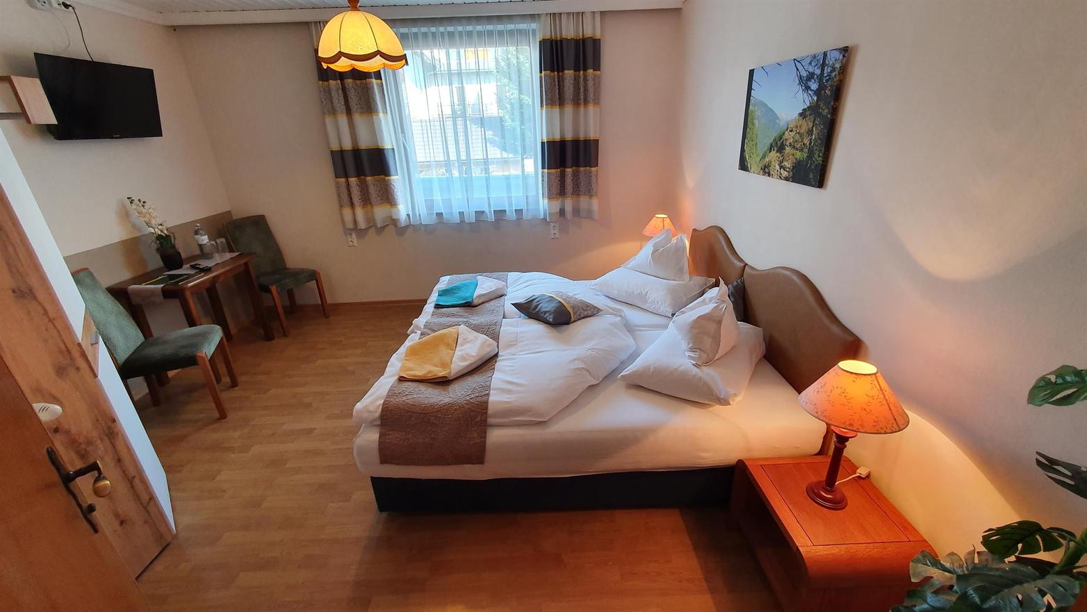 Großes Doppelzimmer mit Doppelbett und Sitzecke.