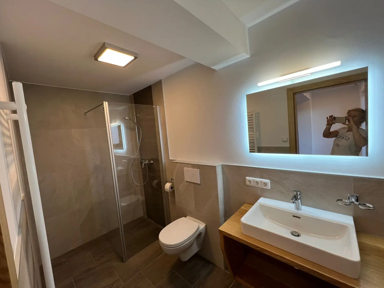 Blick vom Zimmer in das neu renovierte Badezimmer mit Dusche, WC und Waschbecken