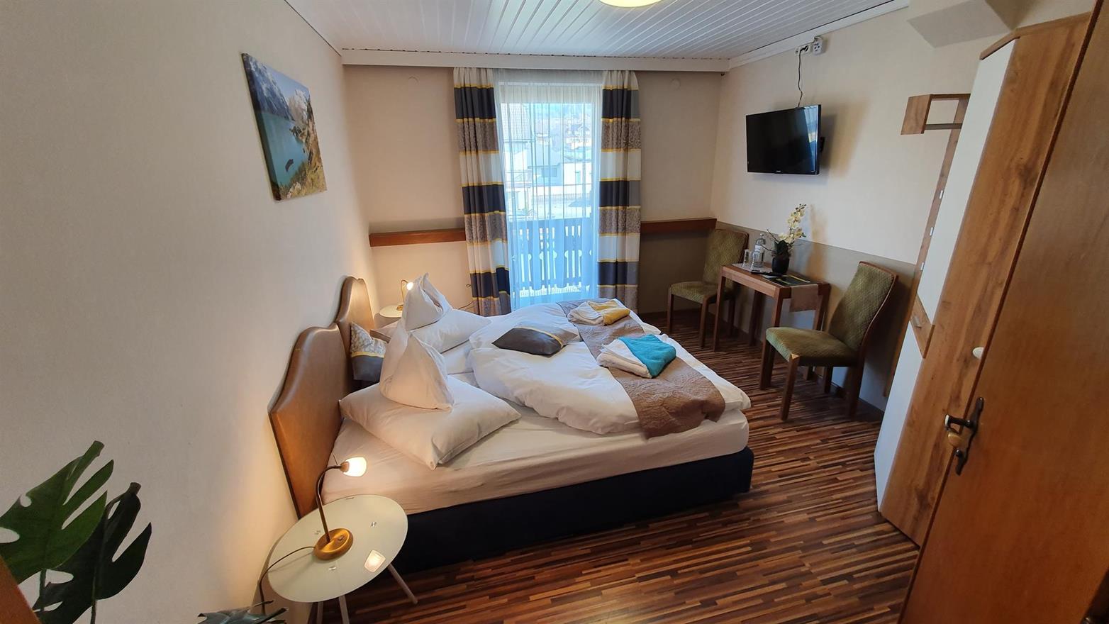 Das kleine Doppelzimmer verfügt über ein großes Doppelbett und eine kleine Sitzecke